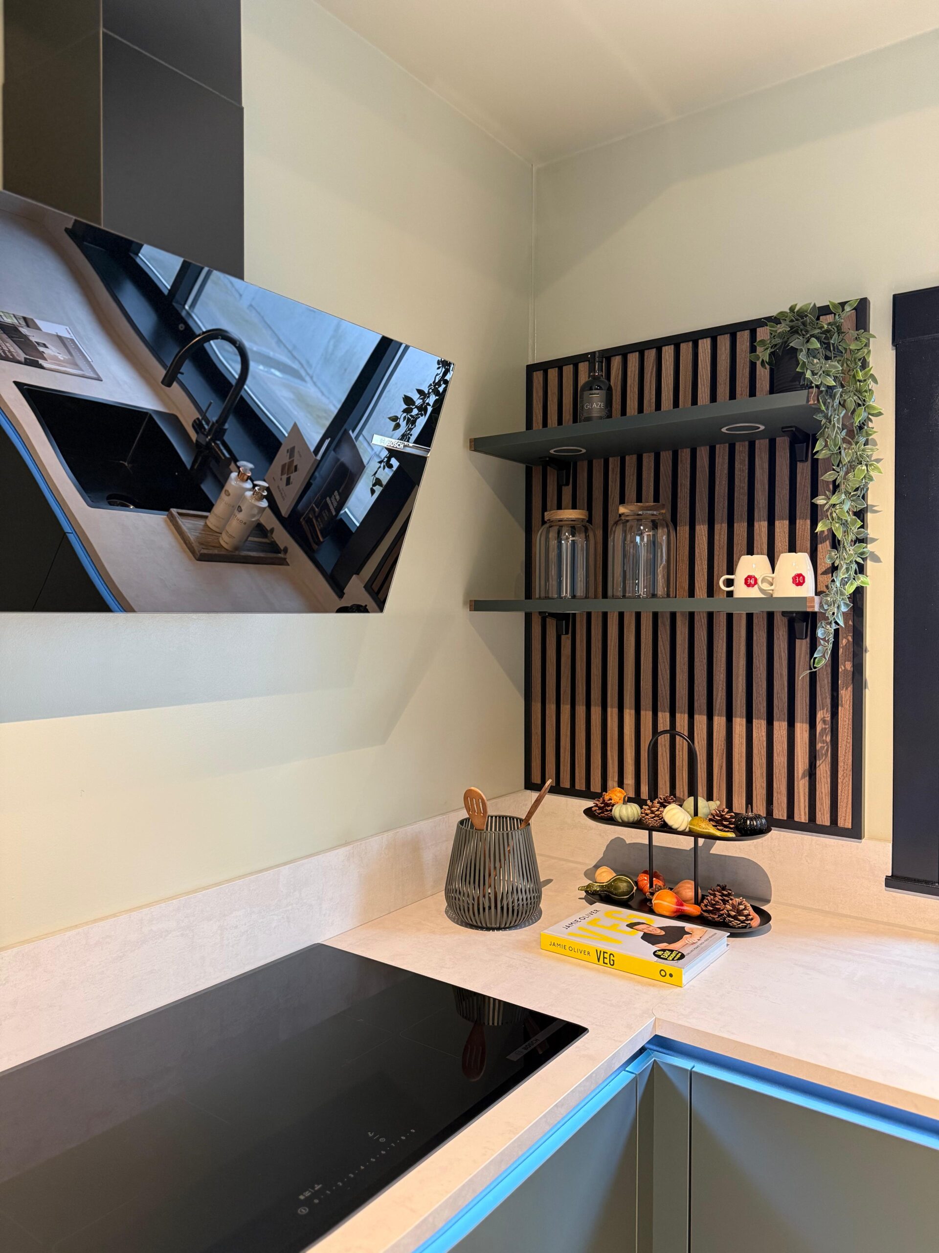 Moderne maatwerk keuken Beverwijk met hoekopstelling, houten lattenwand en geïntegreerde inductiekookplaat